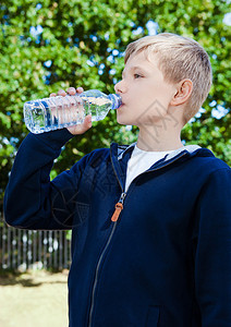 男孩在公园饮用水图片
