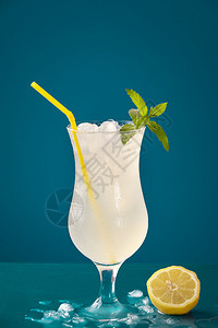 夏天用柠檬冰块和薄粉在蓝桌上喝水冰霜玻璃中补充柠檬饮料图片