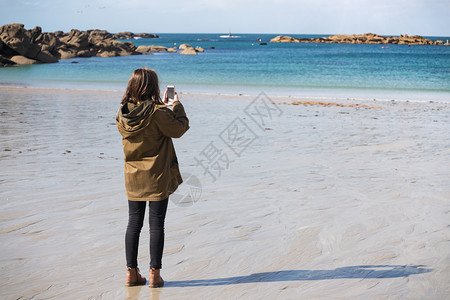 在海边的Triegastl并用智能手机拍照图片