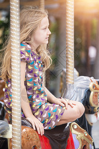 小女孩骑着旋转木马图片