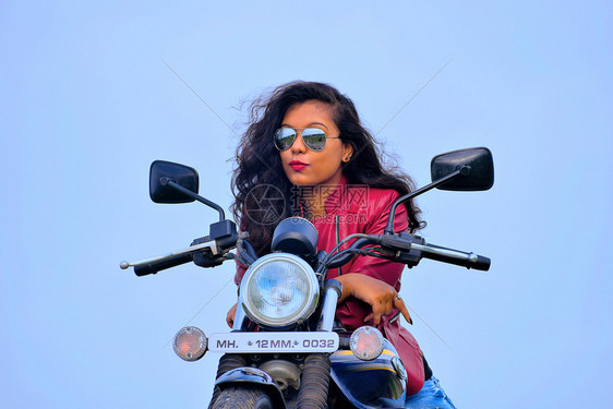 青年女孩坐在摩托车上沉思图片
