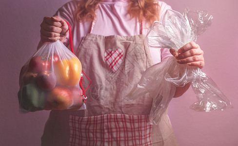 可持续的生活方式概念妇女持有一个生态友好袋配有蔬菜和空置的塑料包装袋图片