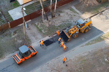 工人挖土机压修理道路图片