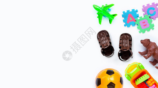 棕色皮革儿童在白色背景上配有多彩玩具的凉鞋图片