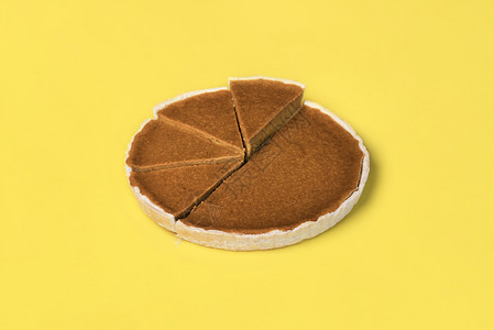 南瓜派切片展示在不均匀的高度上展示在黄色背景上派图概念美国传统的甜点感恩图片