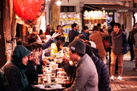 乌尼诺区活跃的繁忙食品街夜生活焦点模糊游客在街边的伊扎卡亚餐厅吃喝图片