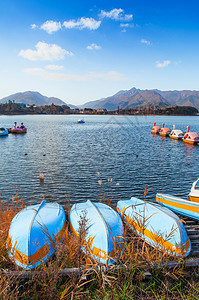 冬季美丽的湖川口子船在岸边搁浅水上自行车船在背景的木头码图片