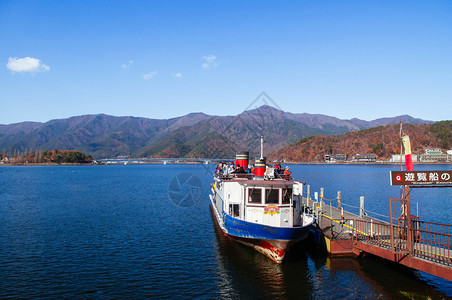 2018年雅马纳什日本湖川口香酒古老的观光旅游船在有山脉的码头和口香酒桥的背景图片