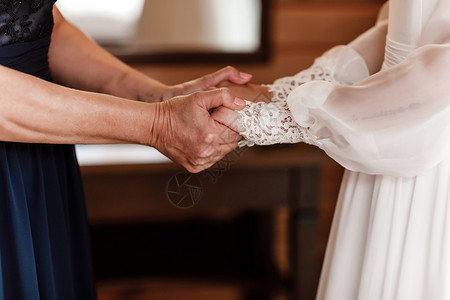在结婚当天新娘与母亲和女儿握手母亲与女儿的关系概念一位老年妇女与轻儿结了婚母亲与女儿之间的关系概念图片