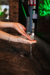 女在咖啡馆洗手水管流在中妇女咖啡馆洗手水从管中流在图片