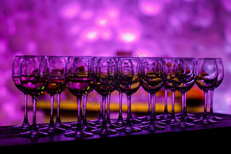 紫色灯光的干件桌子上多杯葡萄酒子加半装站在假日桌上图片