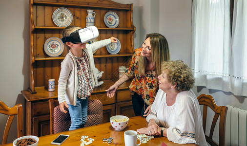 高级妇女与儿和孙使用虚拟现实眼镜高级妇女使用虚拟现实眼镜图片