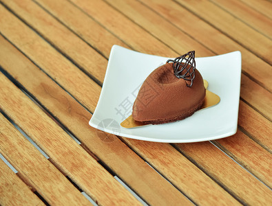 木制桌上的黑巧克力蛋糕图片