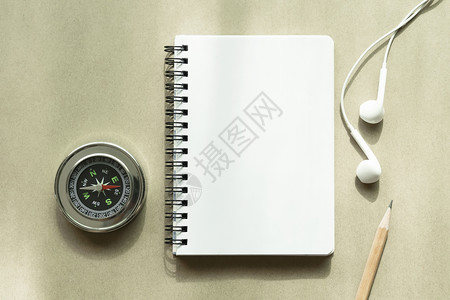 规划旅行背景概念白纸字本空页桌上有铅笔耳机和罗盘背景图片