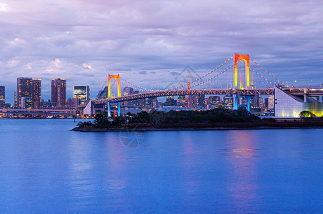 Odaib彩虹桥有明亮的彩色光和东京湾风景在粉红天空下的紫光城市风景下以粉红天空为背景图片