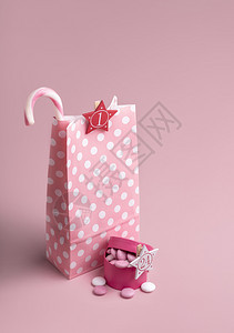 粉红色概念的圣诞节冒险日历带有糖果甘蔗的礼物纸袋和带有粉红色背景糖果的盒子xmas冒险惊喜图片