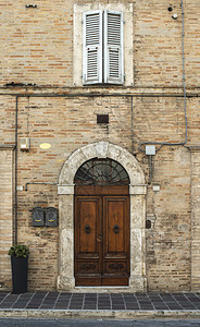典型的意大利式木制门意大利式房子古老的外表阳光圆门拱石头盖房子铁门把手图片