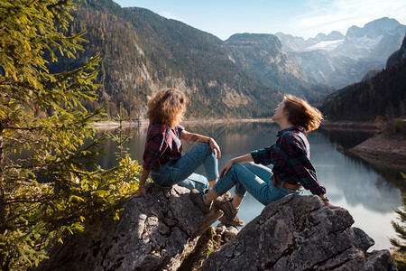 山湖和地背景的两位快乐女孩图片