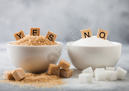 天然棕色和白精炼糖立方体的白色碗盘在浅背景上是的没有字母健康和不的概念图片