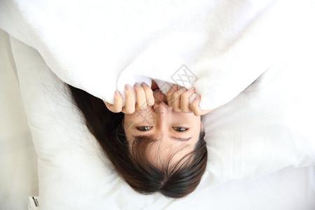 年轻亚洲女在白色卧室微笑图片