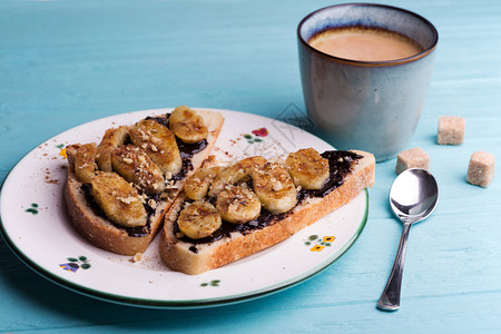 美味的法国早餐面包加巧克力和蓝底的炸香蕉图片