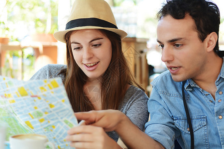 年轻旅游夫妇正在餐厅看旅行概念图片