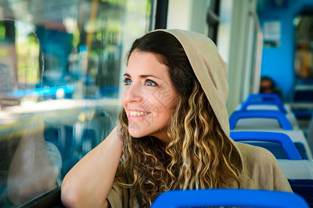 城市年轻女在火车上透过窗户看现代人的生活方式图片