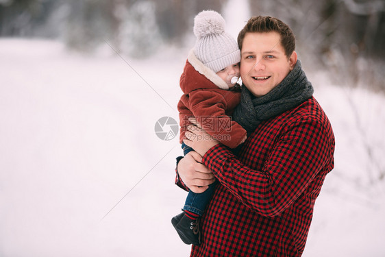年轻父亲抱着小孩子在雪地里玩耍图片