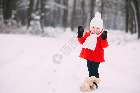 雪小孩穿着红大衣的小女孩和一只泰迪熊在冬天玩得开心女孩在雪地玩耍女孩在冬天玩得开心背景