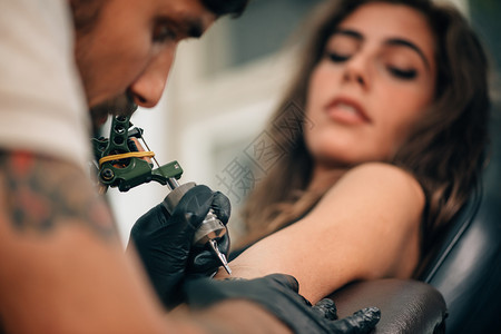 纹身艺术家在女孩上纹身图片