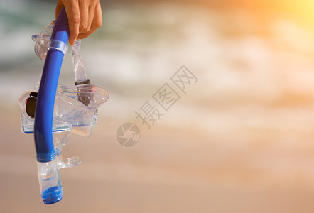 女人在海岸线上手持潜水器背景图片