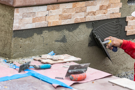 工人们在建筑地安装墙壁瓷砖水泥加土和瓷砖图片