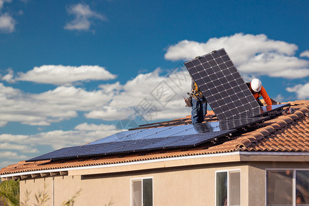 工人在房顶上安装太阳能电池板图片