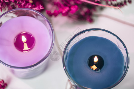 紫色和蓝香蜡烛上面有熏衣草和白桌上的干花装饰图片