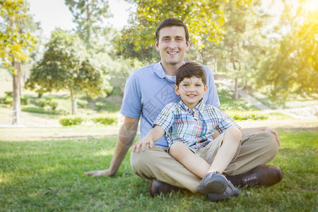 英俊的混合种族父亲和年轻的儿子肖像在公园里图片