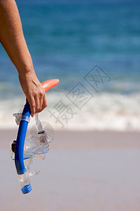 女人在海岸线上手持潜水器背景图片