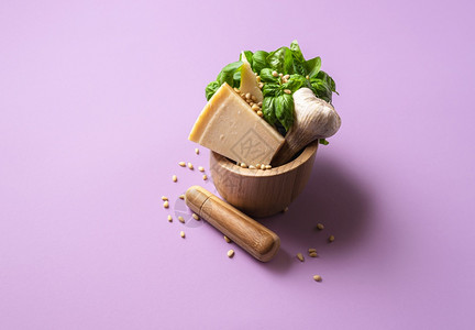 奶香馒头在紫色背景的木制迫击里配上青椒酱成分新鲜的烤肉干酪奶大蒜和松果做青椒面食酱背景