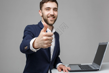 商业概念肖像英俊的商人在他笔记本电脑前露出笑容满脸自信的笑容白色背景复制空间图片