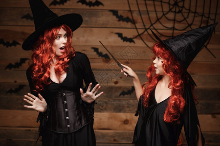 halowen概念红发小巫婆用魔杖施法给母亲用惊吓的魔杖施法神圣的概念红发小巫婆用魔杖施法给她母亲用惊吓的魔杖施法背景图片