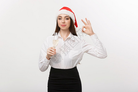 圣诞庆典年轻美丽的商业女人庆祝圣诞节喝着香槟展示好牌子图片