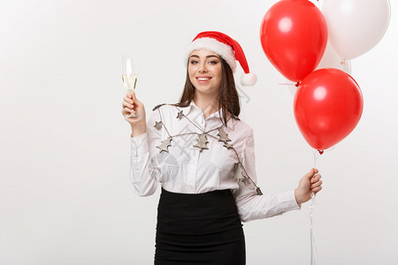 圣诞节庆祝活动年轻美丽的商业妇女庆祝圣诞节喝着香槟和气球年轻美丽的商业妇女庆祝圣诞节喝着香槟和面团背景图片