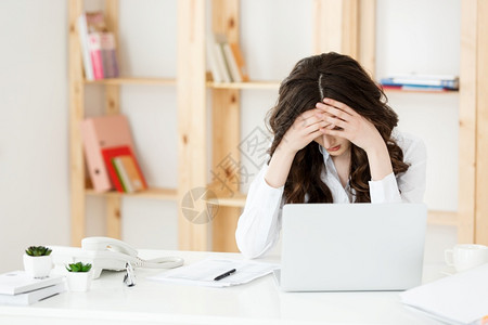 工作中的女孩长期坐在办公室计算机桌的年轻女商人长期坐在办公室计算机桌的年轻女商人背景