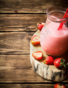杯子里有草莓汁在木制桌上图片