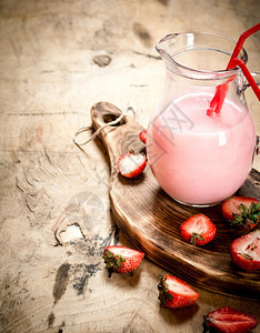 杯子里有草莓汁在木制桌上图片