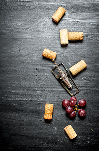 酒瓶子和葡萄枝黑木本底图片