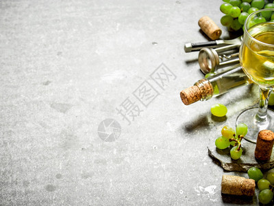 酒瓶和杯中的白葡萄石头桌上的白葡萄酒新图片