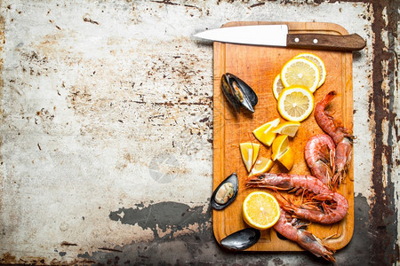 新鲜海产食品虾贝类和柠檬的切割板贝类和柠檬的切割板图片
