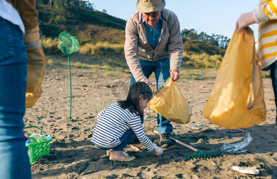 爷和孙女志愿者在海滩上捡垃圾图片