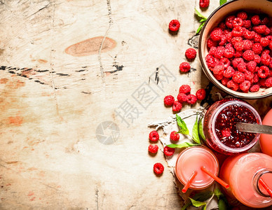 新鲜草莓和果酱的汁在木制桌上图片