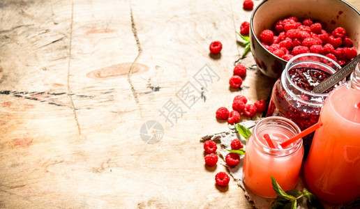 新鲜草莓和果酱的汁在木制桌上图片